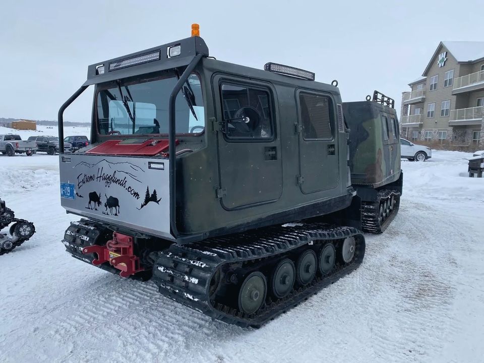 A tracked ice vehicle outside the lodge buildings in winter