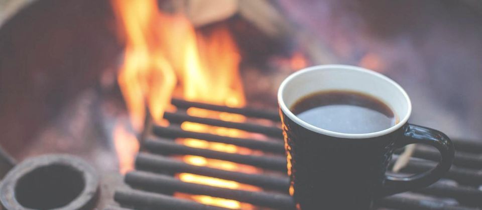 Campfire and a cup of coffee at a Woodland campsite
