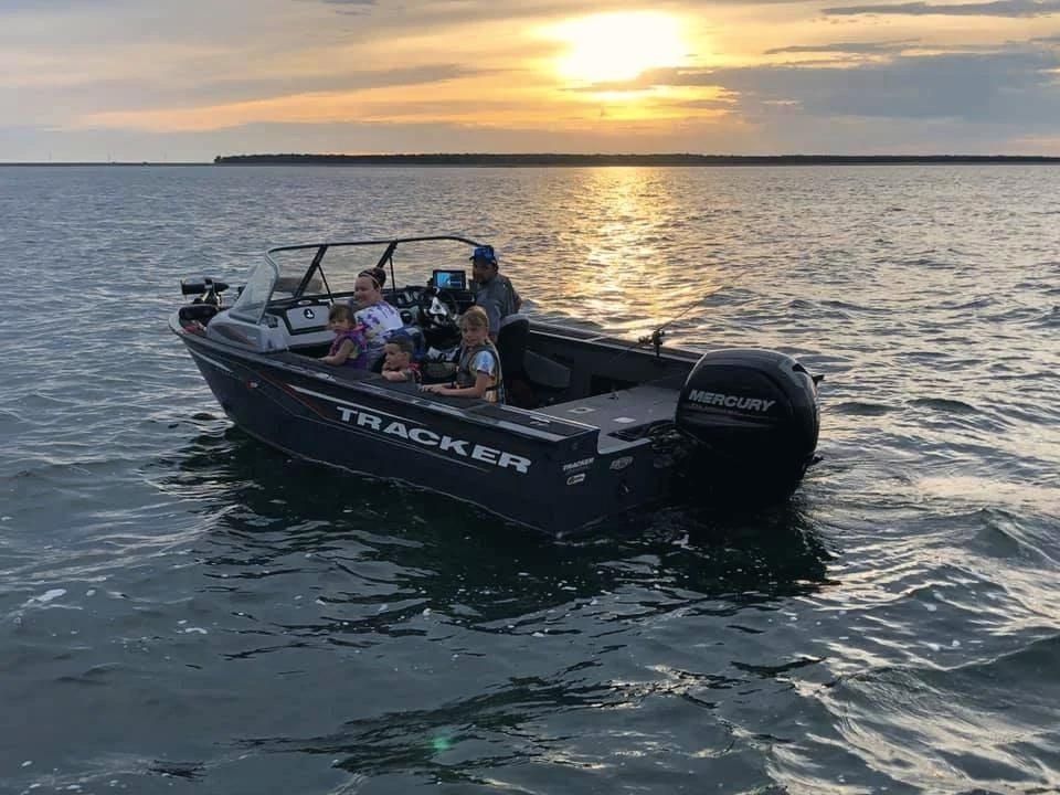 Family in a Tracker fishing boat at sunset on Devils Lake